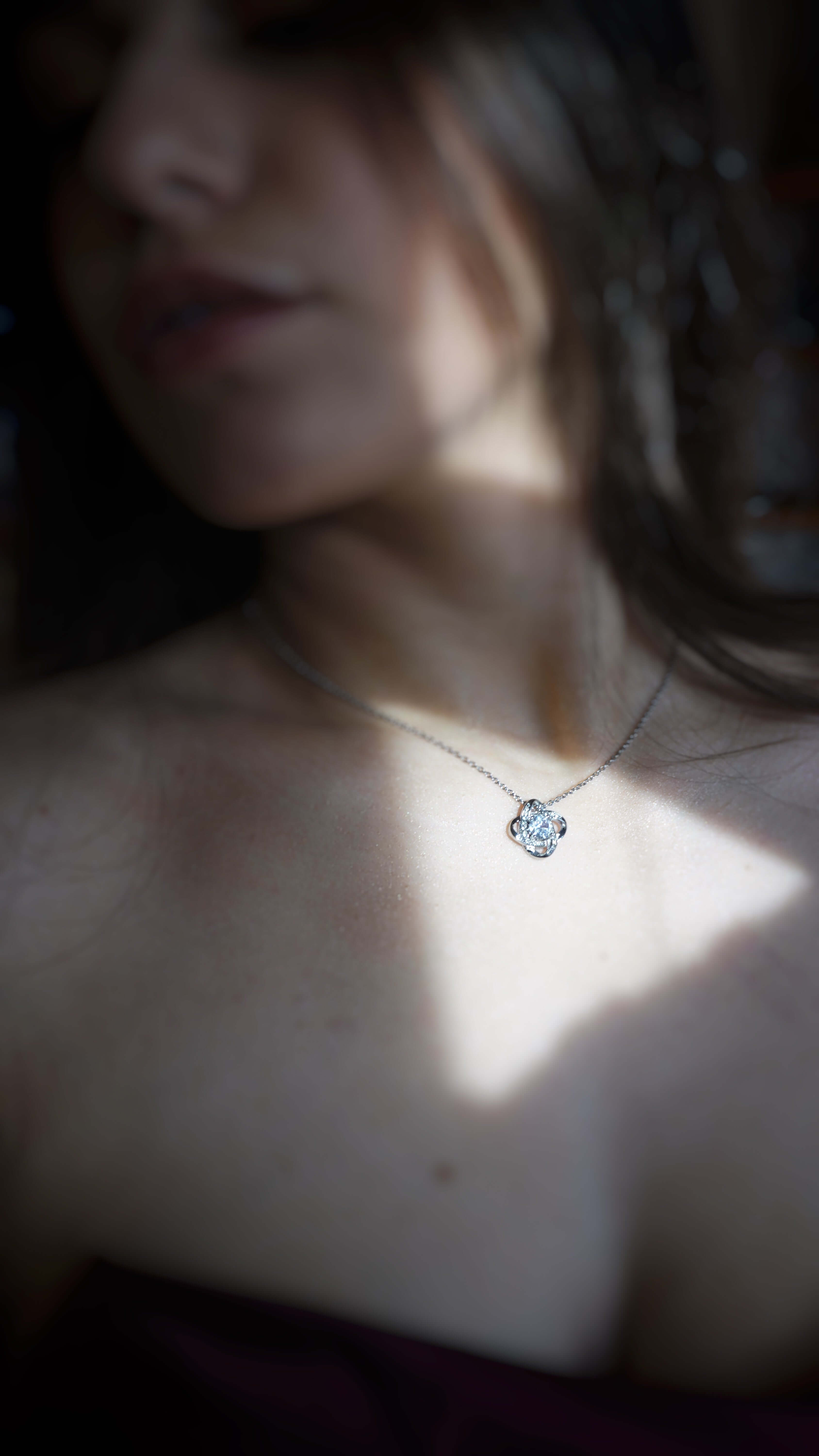 Close-up of a necklace with a pendant on a blurred background