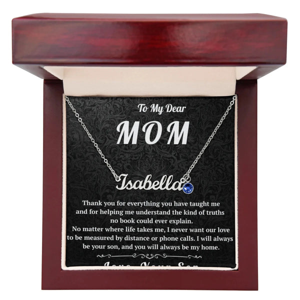 Necklace with a blue gemstone in a wooden box with a personalized message for 'Mom'.