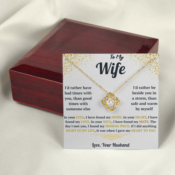 Jewelry box with a gold necklace and sentimental card on a light background