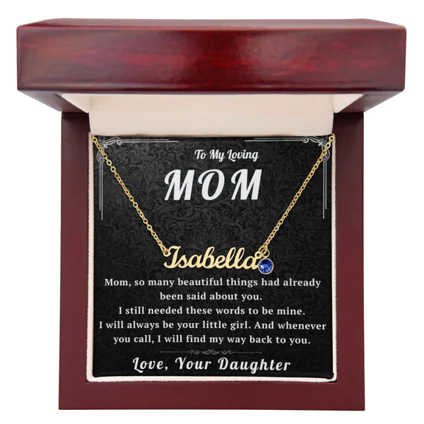 Gold necklace with a blue gemstone on a card for 'To My Loving Mom' in a decorative box.